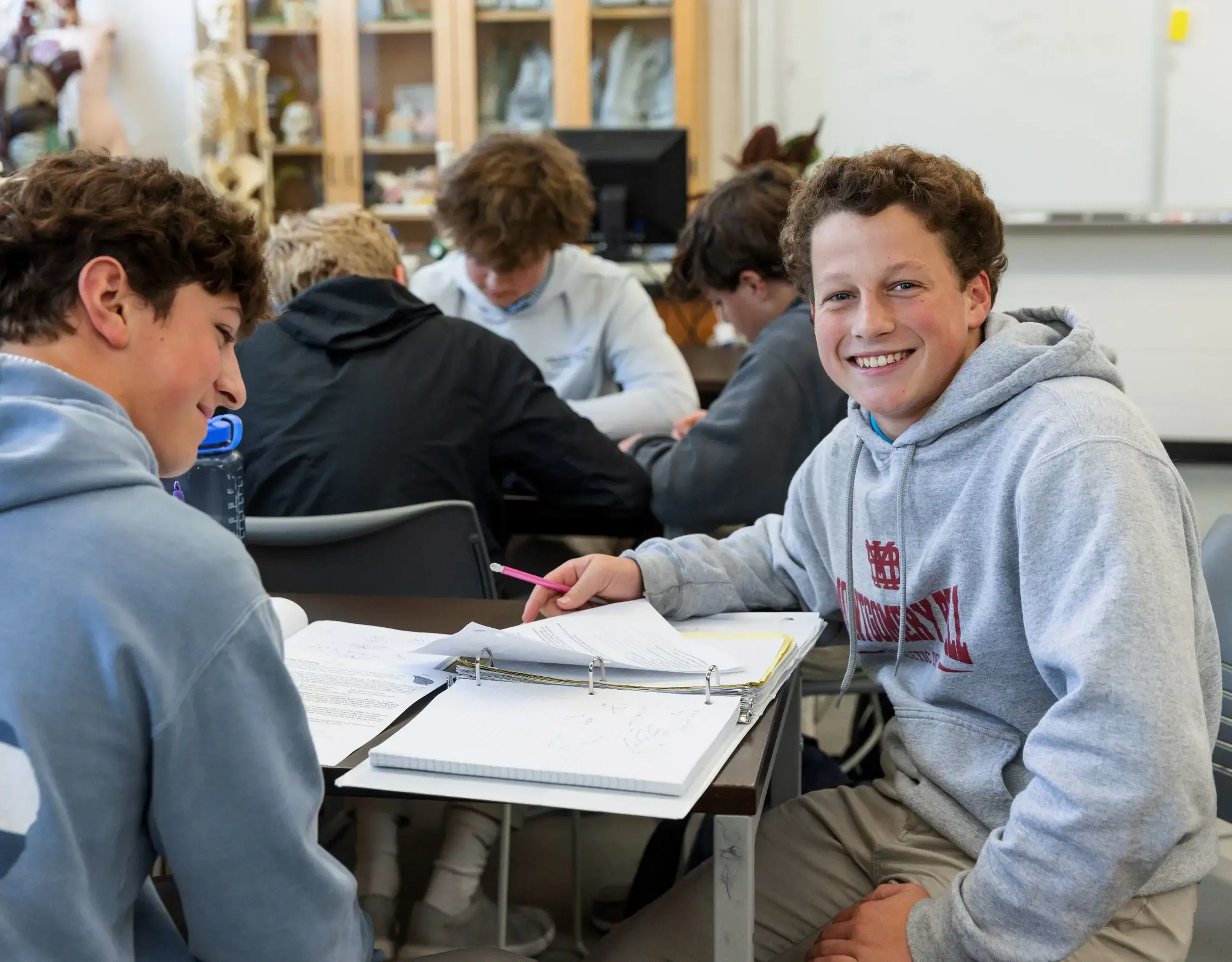 Student at desk smiling