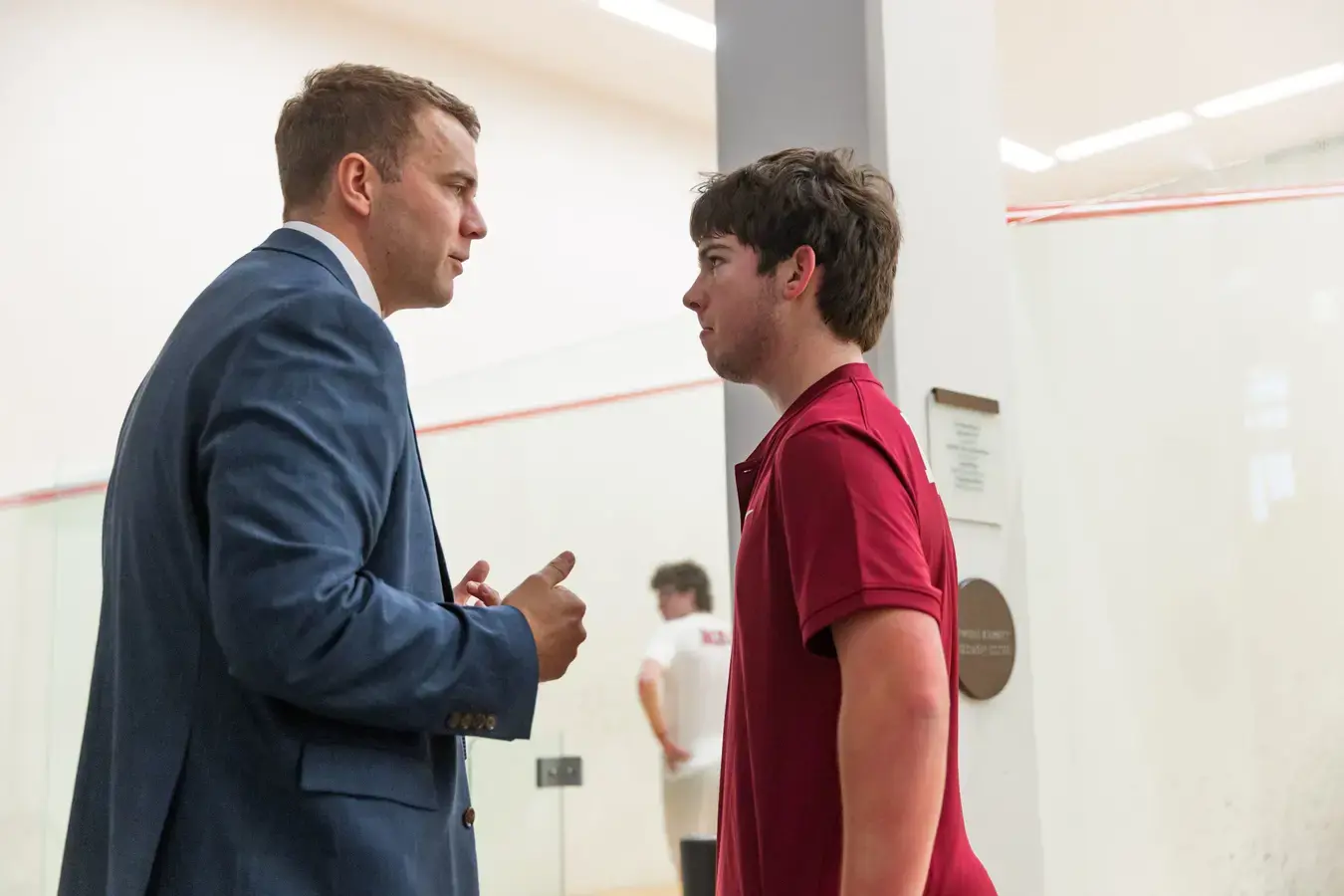 Teacher talking to squash player